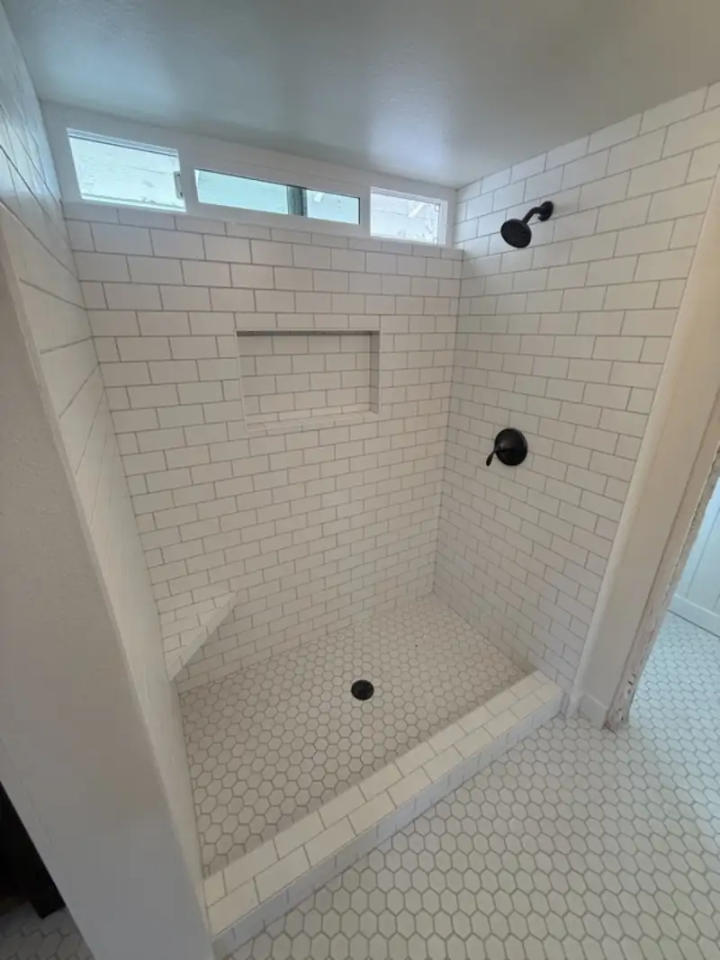 Subway tiled walk-in shower with a recessed niche